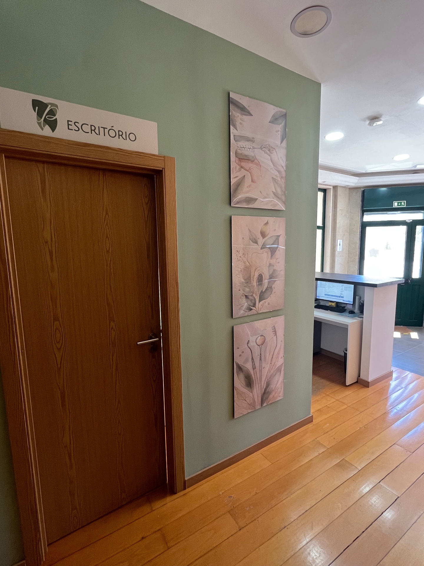 Corredor da clínica com placa de escritório e arte na parede
